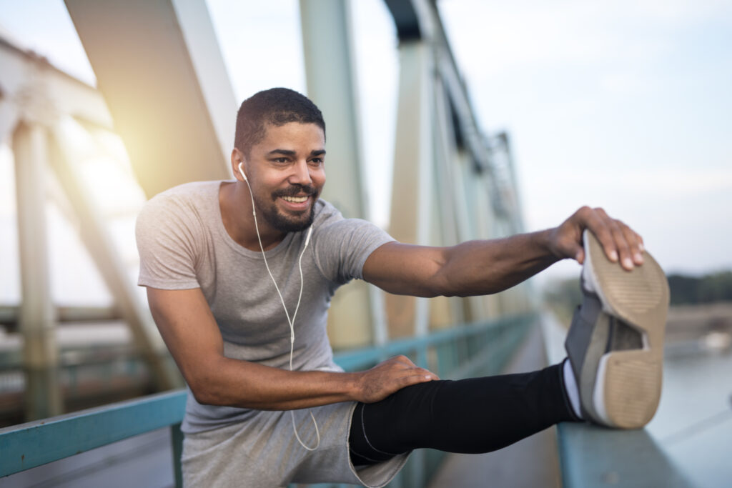 Young smiling sportsman preparing for running.